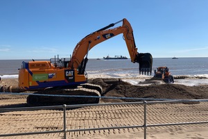 Large equipment moving sand on a beach