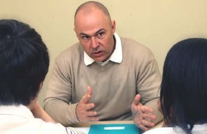 Man sitting at table and talking to two clients