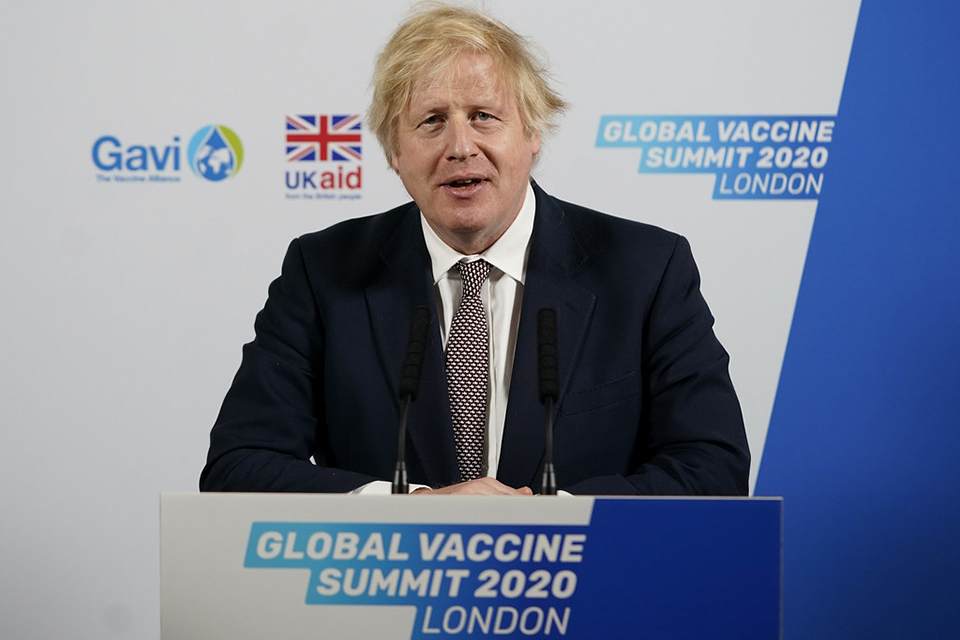 PM Boris Johnson speaking at lectern with banner: Global Vaccine Summit 2020 London