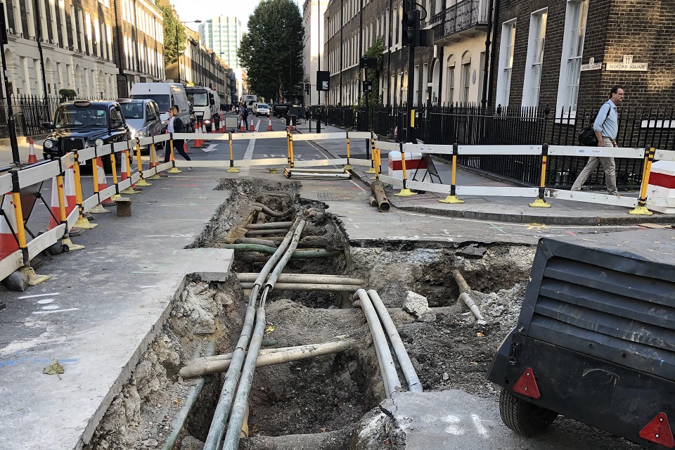 excavation in north London showing buried pipes and cables