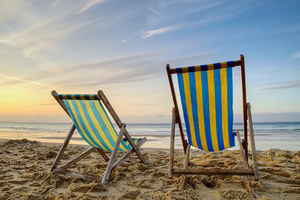 Two deck chairs on an empty beach