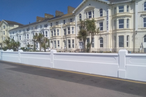 A white wall in front of properties on Exmouth seafront