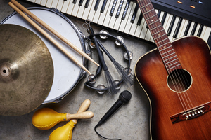 Selection of musical instruments including a  guitar, drum and piano keyboard.