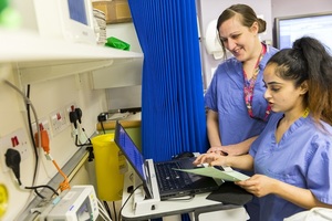 Two nurses looking at a computer screen