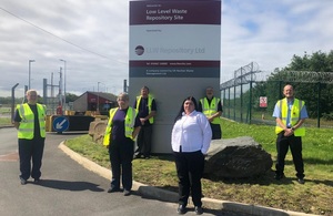 People standing in front of the LLWR totem outside its side.