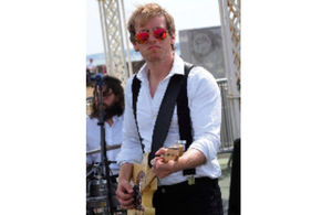 Squadron leader Tom Goble playing the guitar.