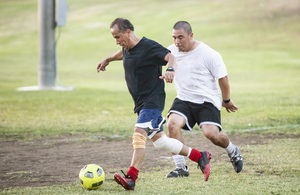 2 men playing football on a sunny evening