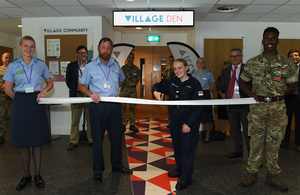 Service personnel in uniform at the entrance of Village. Personnel include: Aircraftman Johnson, Gp Capt Brittain (Defence School of Policing and Administration), Able Seaman Second Class Jenkin & Sapper Prouse. Jenkin is cutting the opening ribbon.