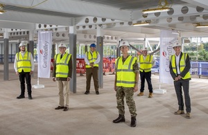 is Project Manager and other key personnel involved in project in PPE stood inside new building under construction