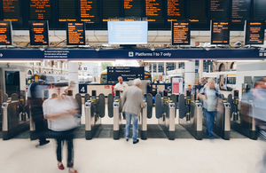 Passengers going through turnstile at railway station