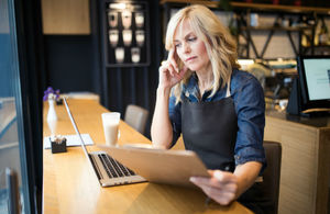 A woman at a laptop looking at a checklist