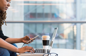 Female business professional working on laptop and phone