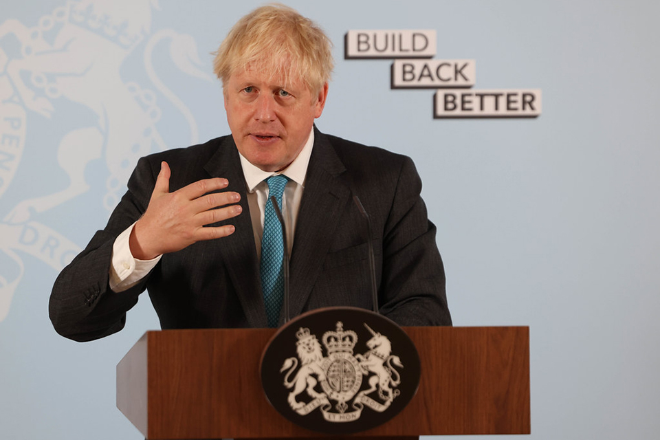 PM Boris Johnson delivering a speech in front of a banner that reads "Build Back Better"