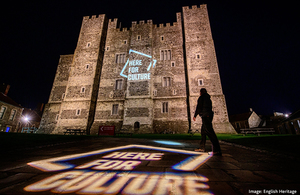 A projection of the Here for Culture logo on the side of Dover Castle