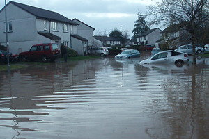 A badly flooded road in Aberdeen Close, St Blazey, with several cars submerged and houses flooded