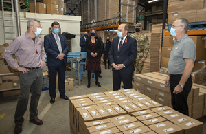 The Defence Secretary stands with staff from The Poppy Factory in their Richmond warehouse