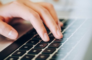 Hand on laptop keyboard