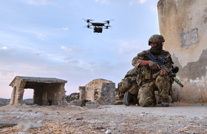 A Royal Marine trains in Cyprus as a drone flies overhead