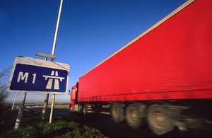 Lorry passing road sign stating start of M1 motorway near Leeds, Yorkshire, UK