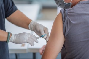 Patient receiving her flu vaccination under COVID-19 conditions