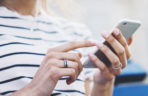 An image of a woman texting on a smartphone