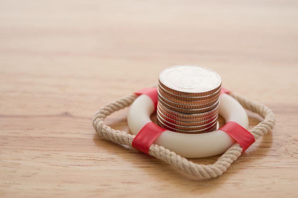 Stack of coins in the centre of a toy life belt