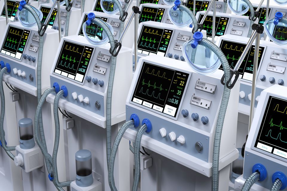 Image shows several rows of medical ventilators.