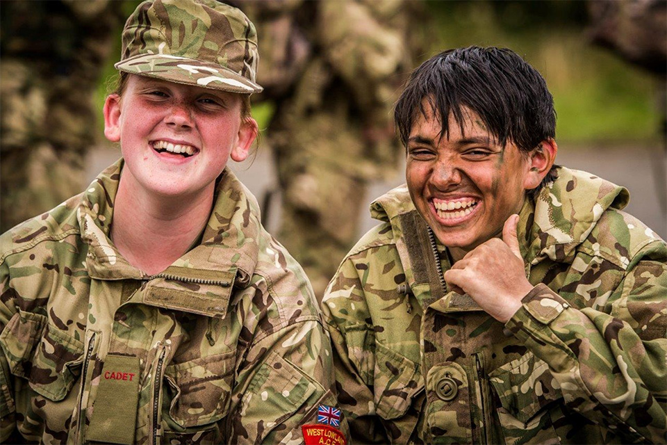 Two young cadets laughing and smiling in their uniform. 