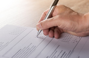 Hand with a pen filling out a survey