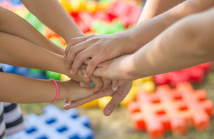 A group of friends all pile their hands on top of each other