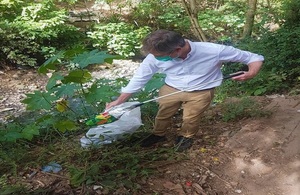 Ambassador picking plastic near a river