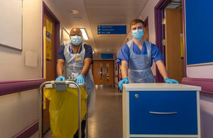 Image depicts two defence medics wheeling trollies down a hospital corridor.