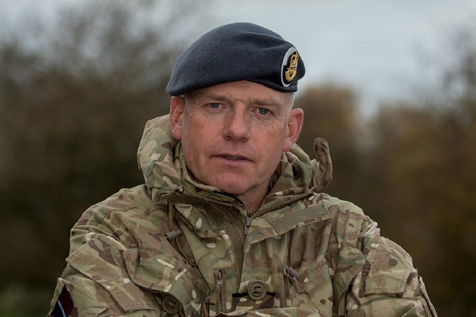 RAF Reservist Flight Lieutenant Mark Grange dressed in full uniform smiling at the camera.