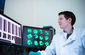 Scientist Adam Taylor in front of computer screens in the laboratory