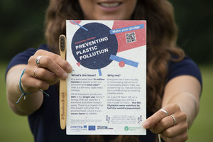 A flyer that is promoting preventing plastic pollution is being held in someone's hands