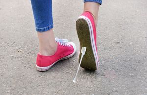 Chewing gum stuck to the bottom of a shoe of a person walking in the street