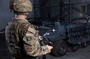 Army soldier holds remote to control computer-driven equipment