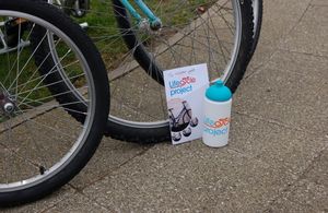 Photograph of bicycle tyres with LifeCycle project pamphlet and plastic water bottle