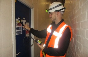 A health physics worker operates a handheld device