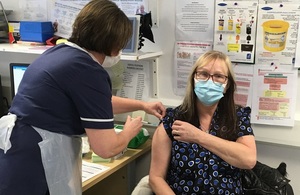 Woman being vaccinated by a nurse.