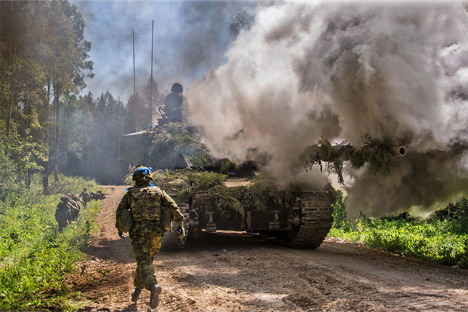 Tank surrounded by smoke and soldiers