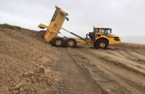 A construction vehicle moving the sand.