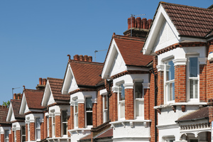 Row of red brick houses with a blue sky in the background