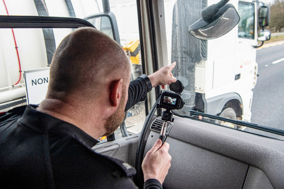 Policeman in passenger seat of supercab fliming evidence of dangerous driving on motorway