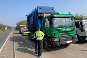 Environment Agency officer and a man talking to the driver of a lorry carrying waste