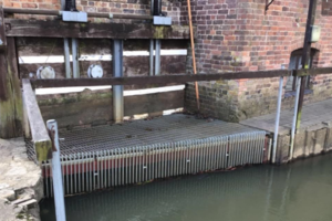 Grill like structure that is part of a flood defence