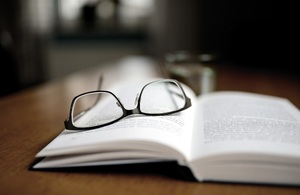 Open book with reading glasses on top