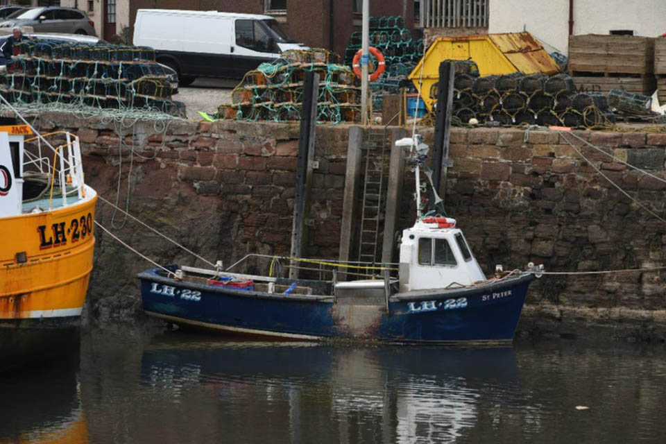 Photograph of fishing vessel Saint Peter alongside harbour wall