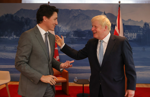 Boris Johnson puts his hand on Justin Trudeau's shoulder.