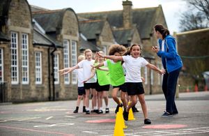 Children doing physical activity in a playgroup supervised by a teacher